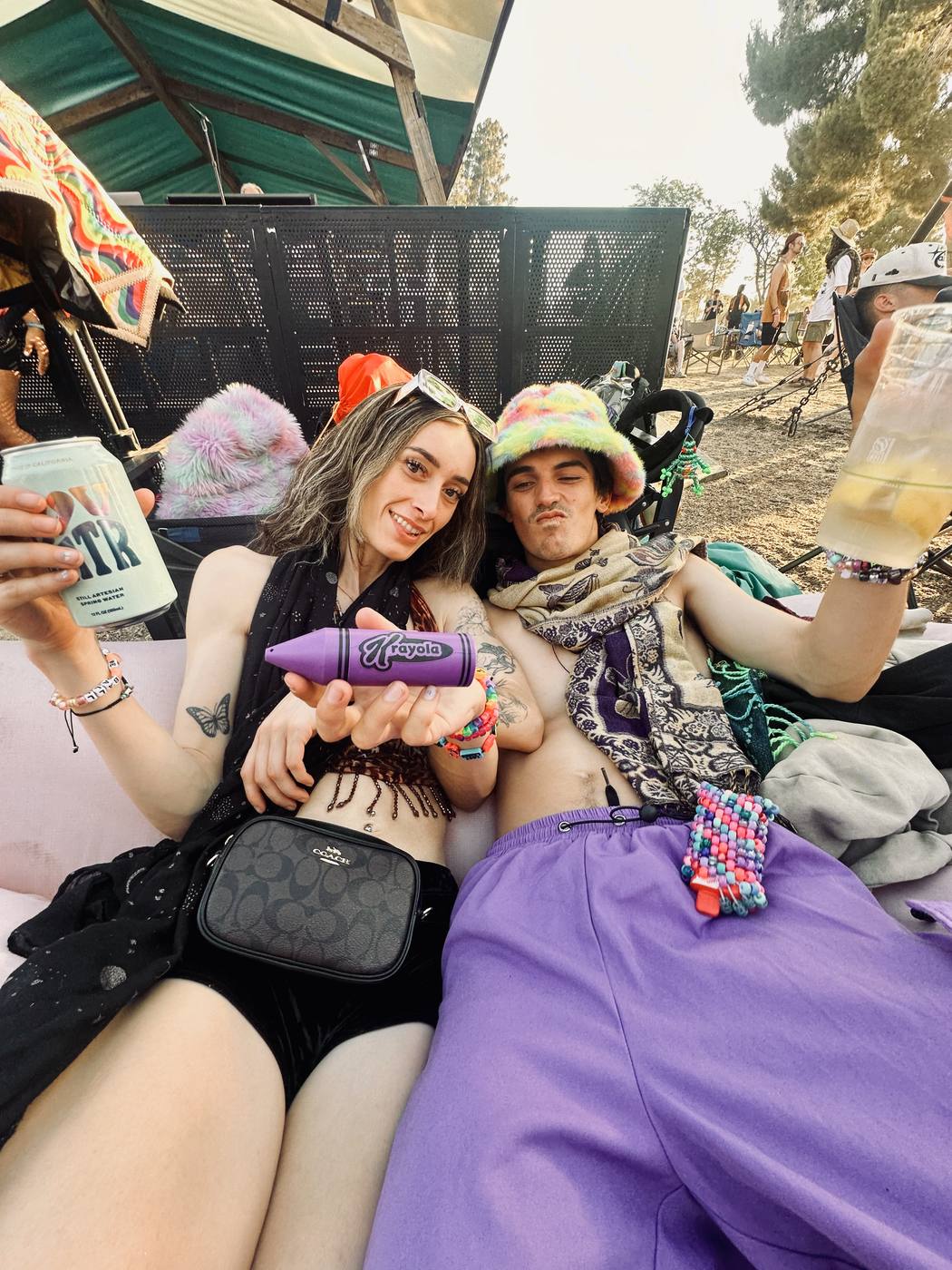 Two festivalgoers holding a violet Krayon